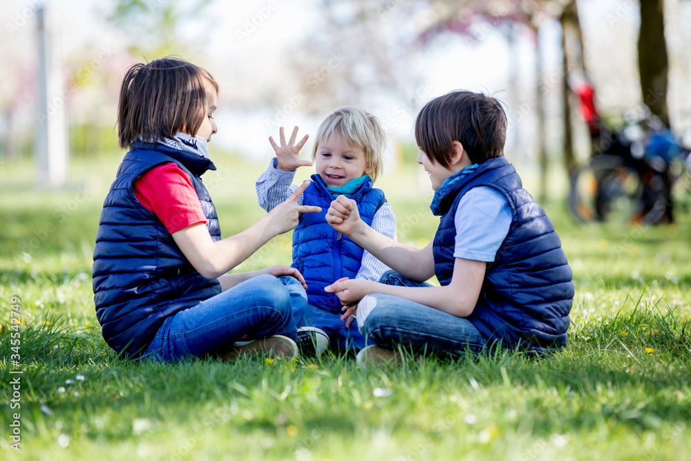 Two children, boy brothers, playing rock scissors paper game Two children, boy brothers, playing rock scissors paper game