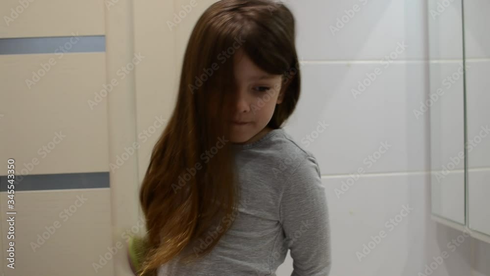 Little charming baby girl combing her long hair with a comb Little charming baby girl combing her long hair with a comb