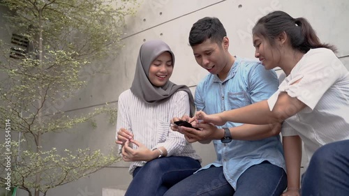 three friend muslim talk and using mobile phone together
