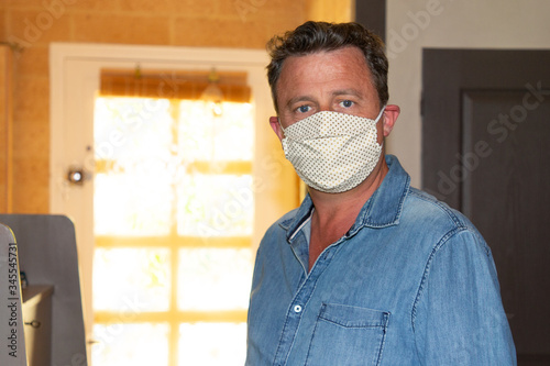 handsome man with face mask homemade in home quarantine lockdown covid-19 coronavirus pandemic contagious disease photo