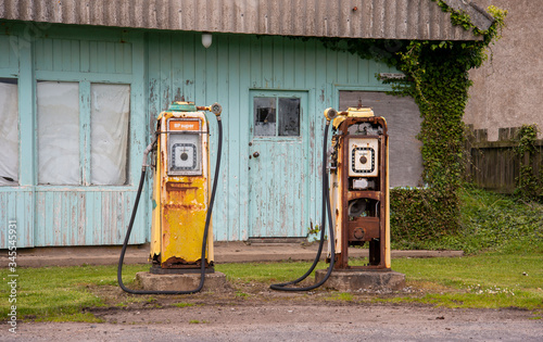 old petrol pumps rusting at abandoned gas station