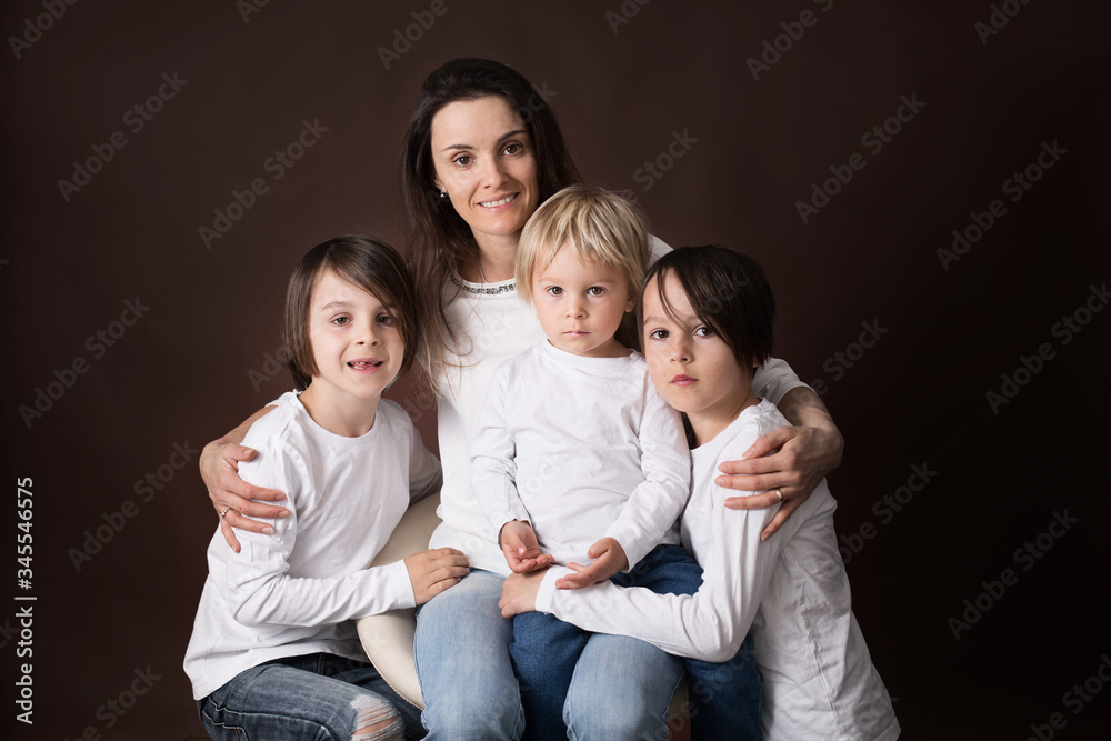 Three beautiful children, boy brothers, having family portrait, hugging