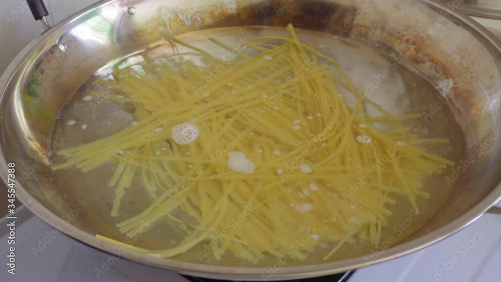 Pasta Boiled In Boiling Water In A Pan.Italian Cuisine.Close Up Spaghetti In Boiling Water.Linguine Cooked In A Pan. Pasta Boiled In Boiling Water In A Pan.Italian Cuisine.Close Up Spaghetti In Boiling Water.Linguine Cooked In A Pan.