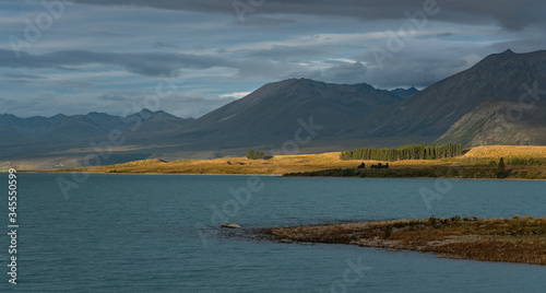 Lake Tekapo  New Zealand - January 8  2020   Golden light hitting the mountains in the background of Lake Tekapo on a late afternoon