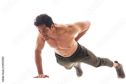 Man doing push ups with one hand in front of a white background. 
