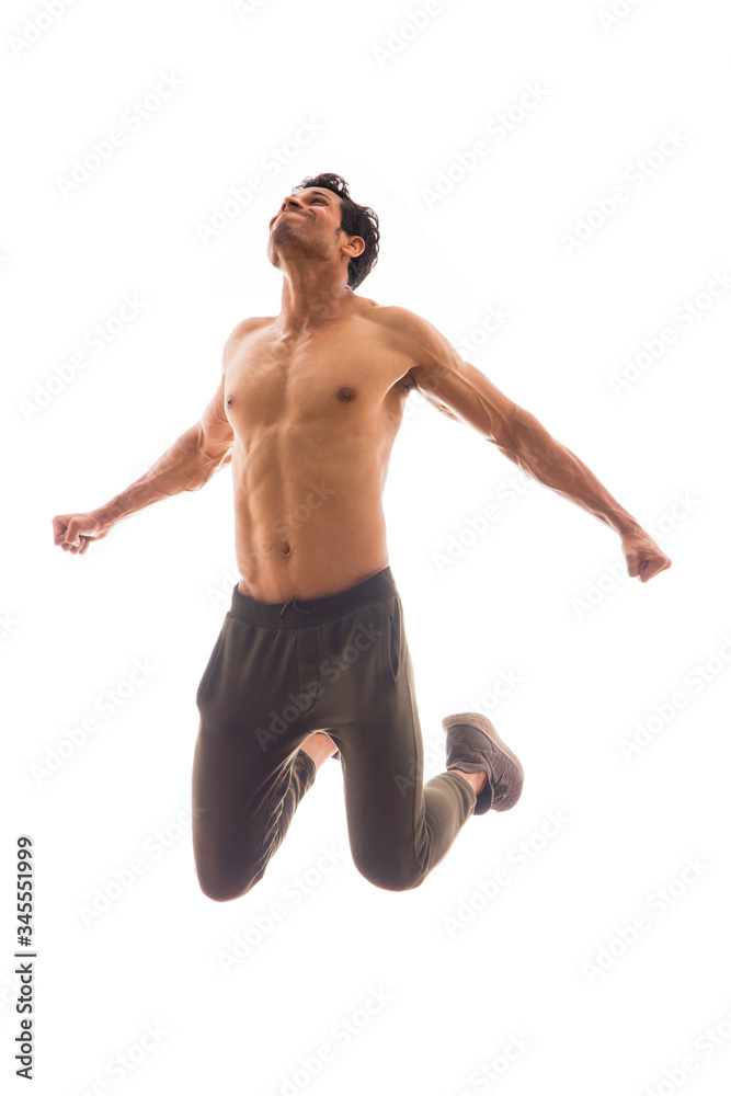 Man jumping bare chested in front of a white background. 
