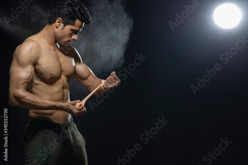 Man tying a cloth in his fist before his workout. 