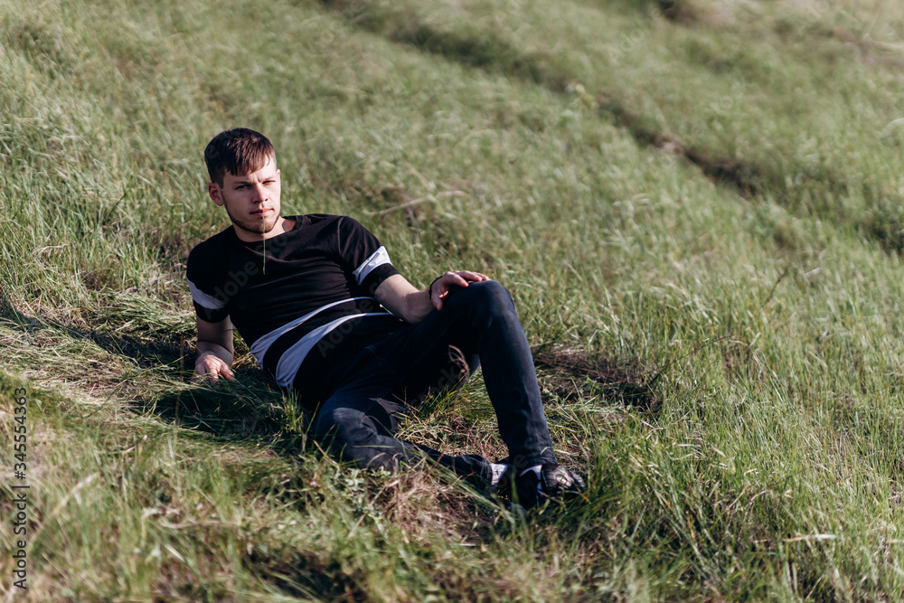 young guy on green grass hills lawn