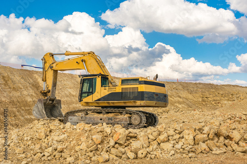 Excavator in a quarry extracting stone