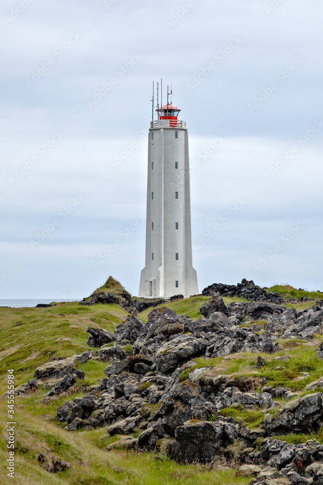 Rocket-shaped lighthouse surrounded by volcanic rocks