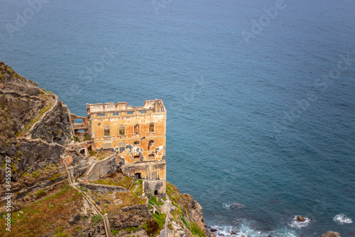 Abandoned building on a cliff by the sea photo