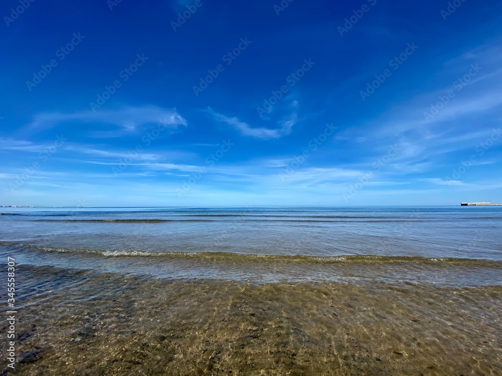 The cleanest sea on a city beach in Valencia, Spain. Clear water and blue sky. Сoastline The cleanest sea on a city beach in Valencia, Spain. Clear water and blue sky. Сoastline