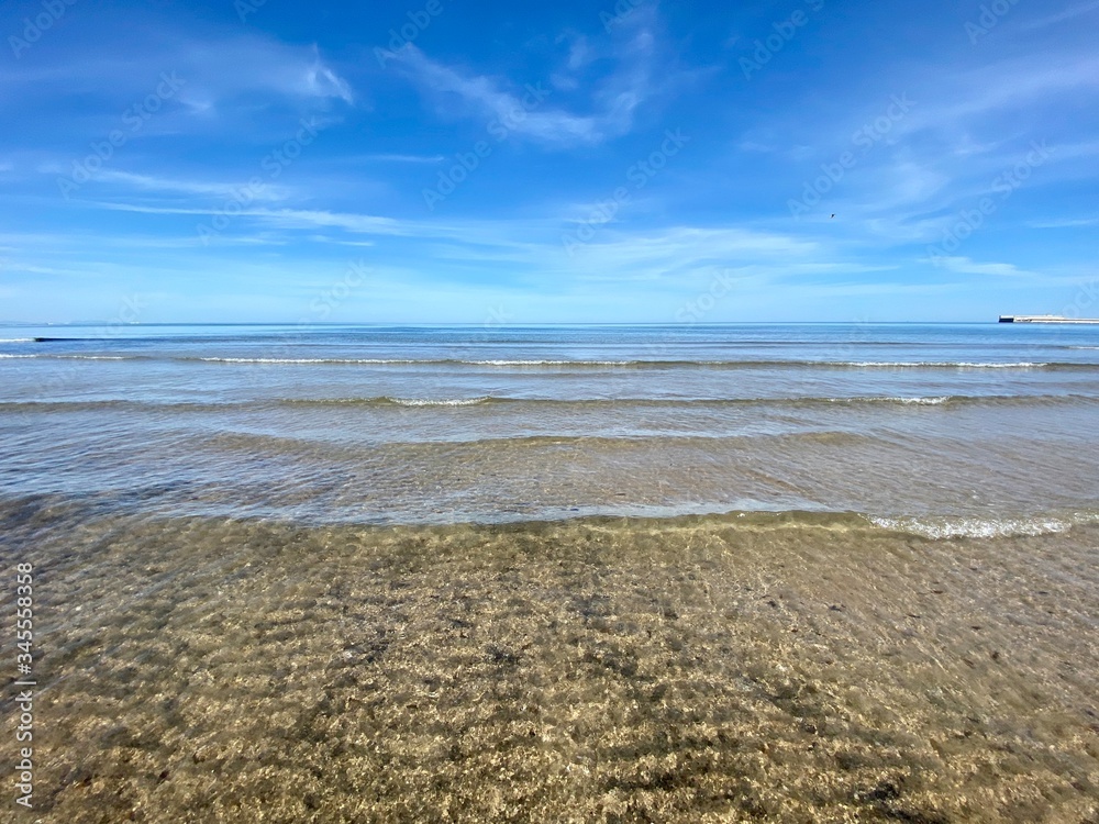 The cleanest sea on a city beach in Valencia, Spain. Clear water and blue sky. Сoastline The cleanest sea on a city beach in Valencia, Spain. Clear water and blue sky. Сoastline