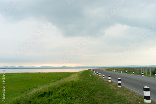 road near lagoon with green grass