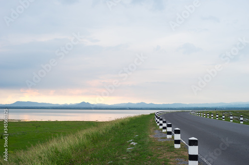 road near lagoon with green grass
