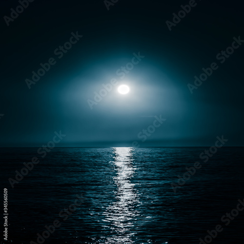 Moon over the sea. Moonlight on the sea. Night sky. A patch of moonlight on the surface of the night sea.