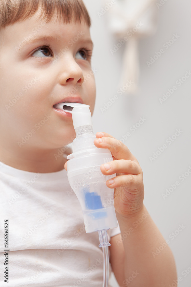The boy makes inhalations. Treatment at home. Disease prevention The boy makes inhalations. Treatment at home. Disease prevention