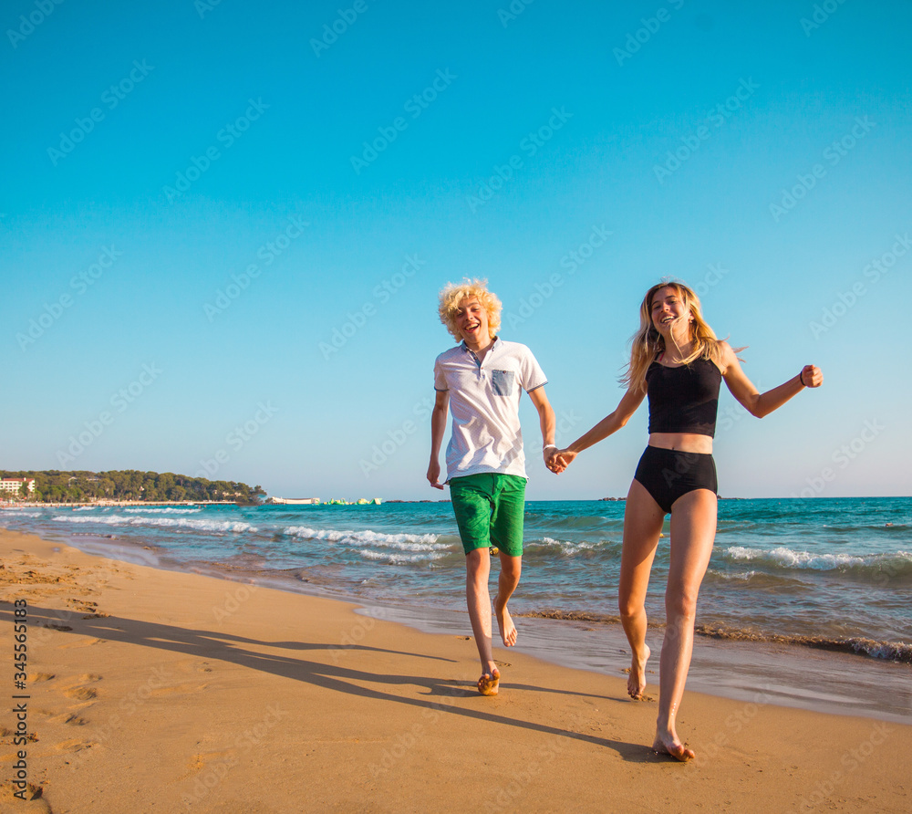 Happy young couple having fun at beach on sunny day Happy young couple having fun at beach on sunny day