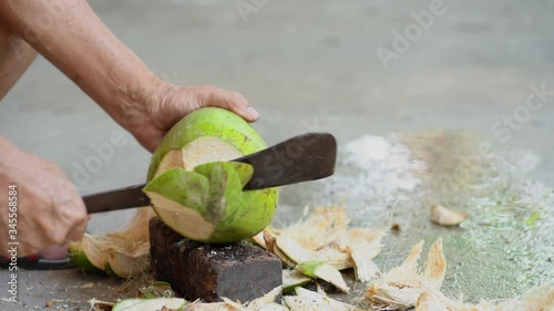 Green fresh coconut peeling and shelling with heavy chop knife for juice.	