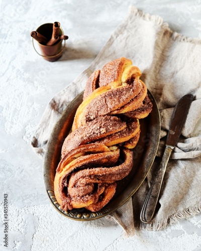 Cinnamon twisted loaf bread or babka on a dark wooden background, still life, rustic style