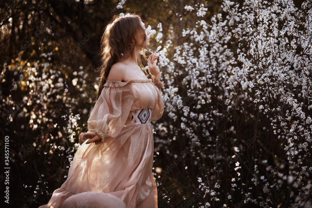 girl in a beautiful airy dress in spring in white colors. nature walk girl in a beautiful airy dress in spring in white colors. nature walk