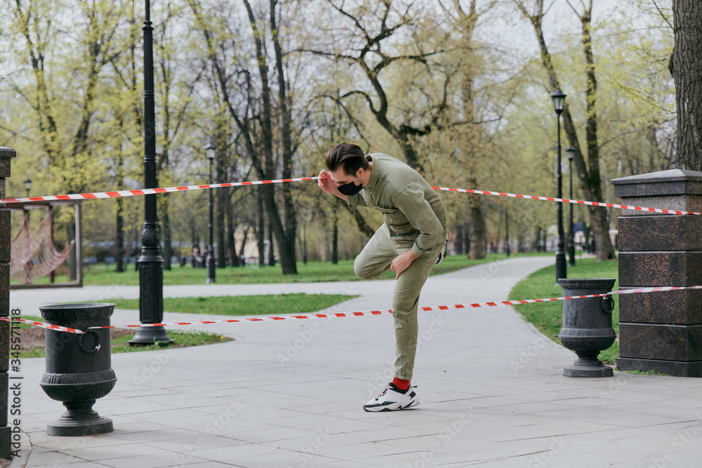 Obraz premium A man climbs over the fence. Violation of the ban on movement in parks and squares. Coronavirus