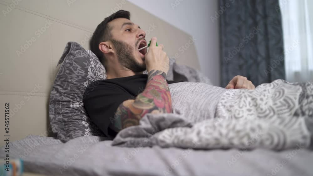 Coughing man taking his medicines during home quarantine Coughing man taking his medicines during home quarantine