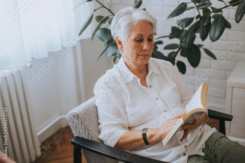 Senior woman reading book i...