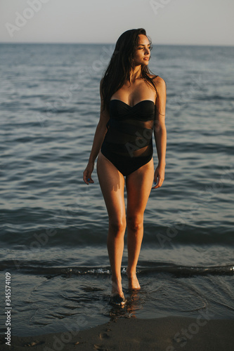 Young woman walking in wate...