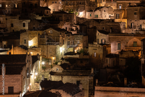 Amazing lighted buildings in ancient Sassi district by night in Matera, well-known for their ancient cave dwellings. Basilicata. Italy