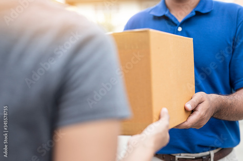 Woman hand accepting a delivery boxes of paper containers from deliveryman. © Patcharin