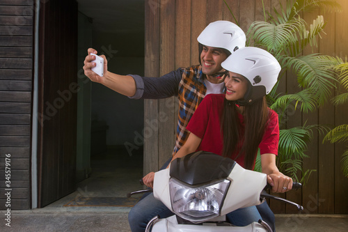 Canvas Print Young couple taking selfie sitting on motorbike