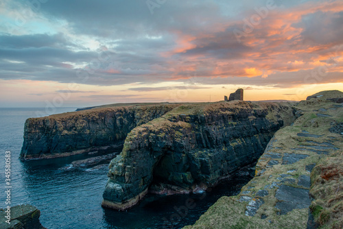 sunset on Old Wick Castle circa 1100 sits on a dramatic promontory  photo