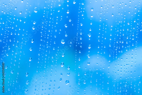 blue rain water drops on a window close up , colored drop macro in a blue light © Yaroslav