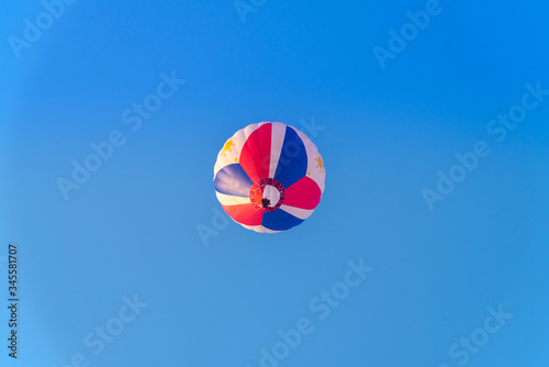 Close up hot air balloon flying up on cosmos field with blue sky background