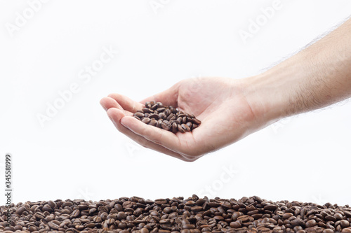 Hand holding roasted coffee beans,isolated in white background