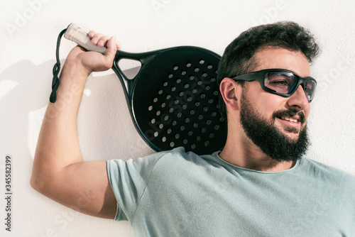 Paddle tennis player posing on white background photo