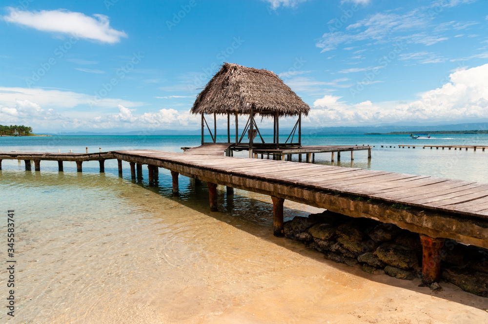 Cabin in blue sea with wooden path on the water