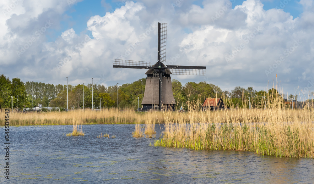 Tradycyjny, holenderski wiatrak nad kanałem wodnym, Alkmaar w Holandii Północnej.