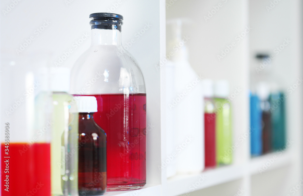 Many different bottles and test tubes with liquids of different colors stand on the shelf. Pharmacy. Many different bottles and test tubes with liquids of different colors stand on the shelf. Pharmacy.