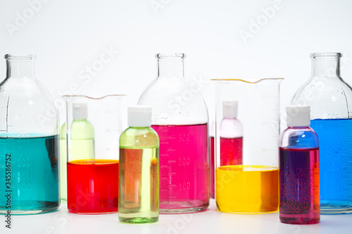 Glass bottles and flasks of different sizes with liquids of different colors on the background. Chemical lab.