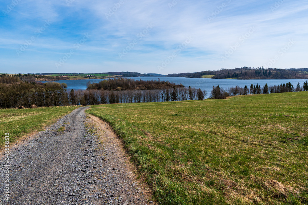 Fototapeta premium pasture with beautiful lake and blue-white sky on a sunny day