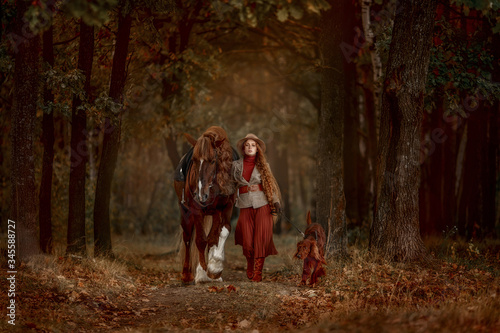 Photography Beautiful long-haired blonde young woman in English style with red draft horse,