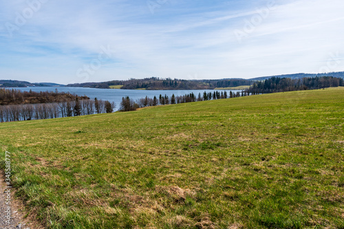 pasture with beautiful lake and blue-white sky on a sunny day