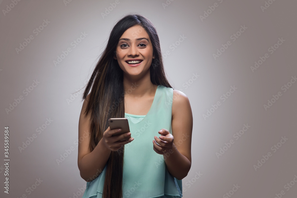 Portrait of a smiling teenage girl holding her mobile phone
Portrait of a smiling teenage girl holding her mobile phone