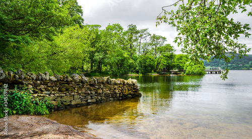 The bank of Ullswater in the Lake District showing the rambling hills and calm water. 