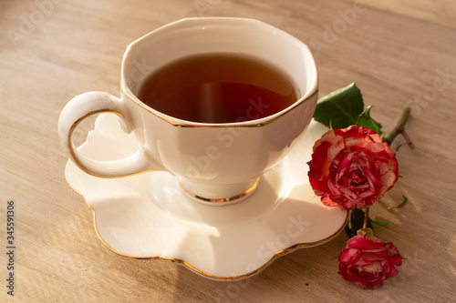 Healthy tea in white classic cup with roses, vintage image