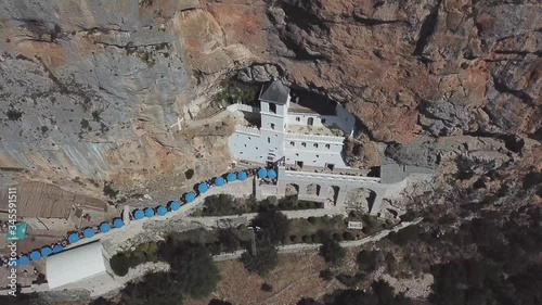 Aerial view of The Monastery of Ostrog, Serbian Orthodox Church situated against a vertical background, high up in the large rock of Ostroška Greda, Montenegro. Dedicated to Saint Basil of Ostrog 
