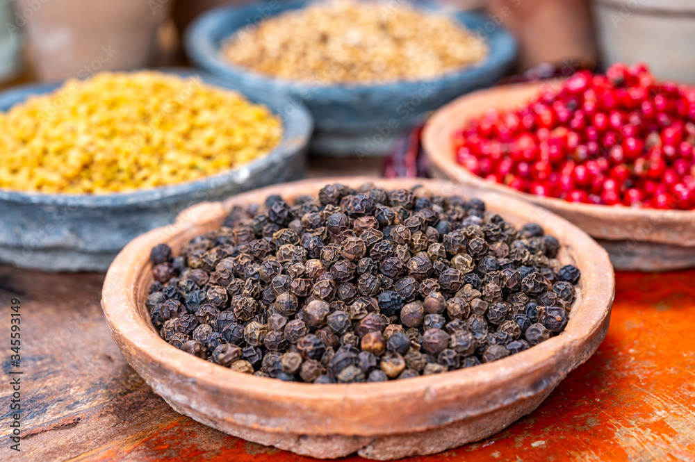 Indian spices collection, dried black peppercorns and another spices in clay bowls Indian spices collection, dried black peppercorns and another spices in clay bowls