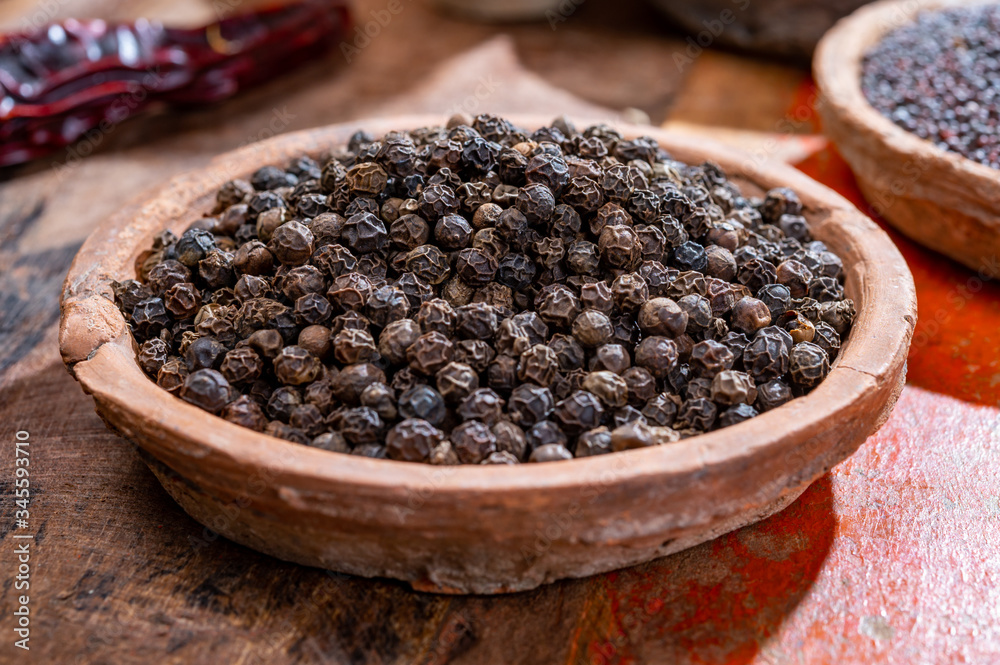 Indian spices collection, dried black peppercorns and another spices in clay bowls Indian spices collection, dried black peppercorns and another spices in clay bowls
